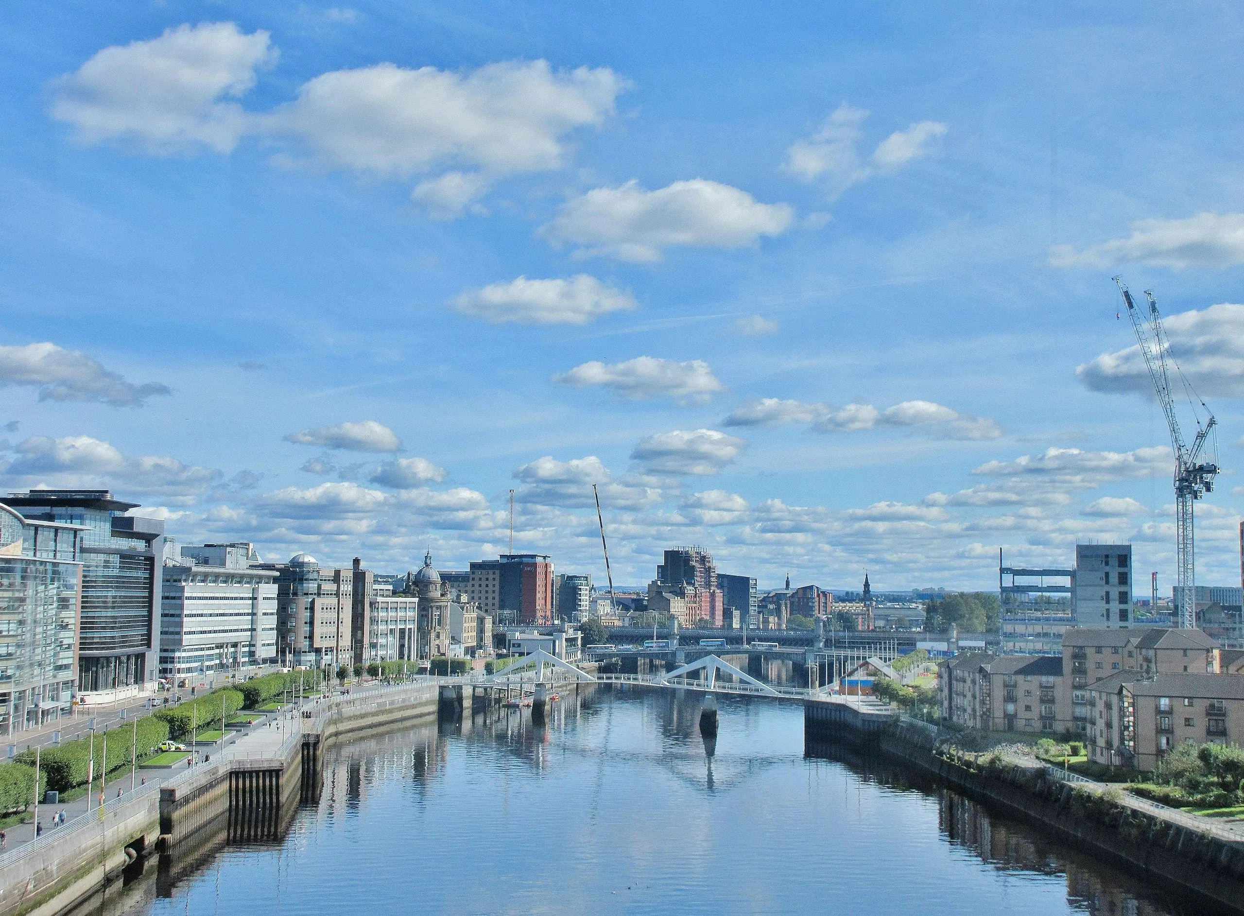 The River Clyde running through Glasgow city centre under a blue sky