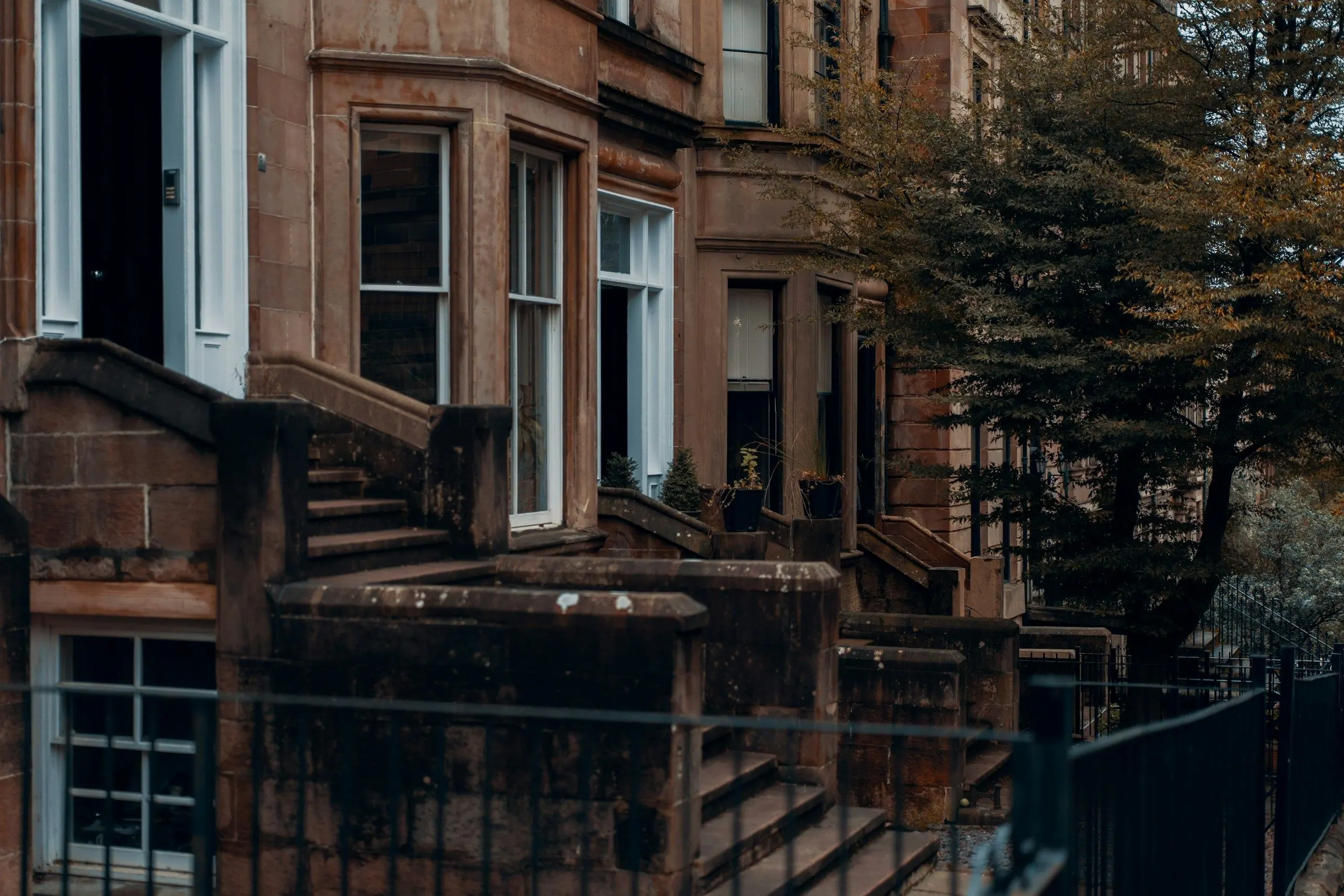 Red sandstone tenements with bay windows on a Glasgow street