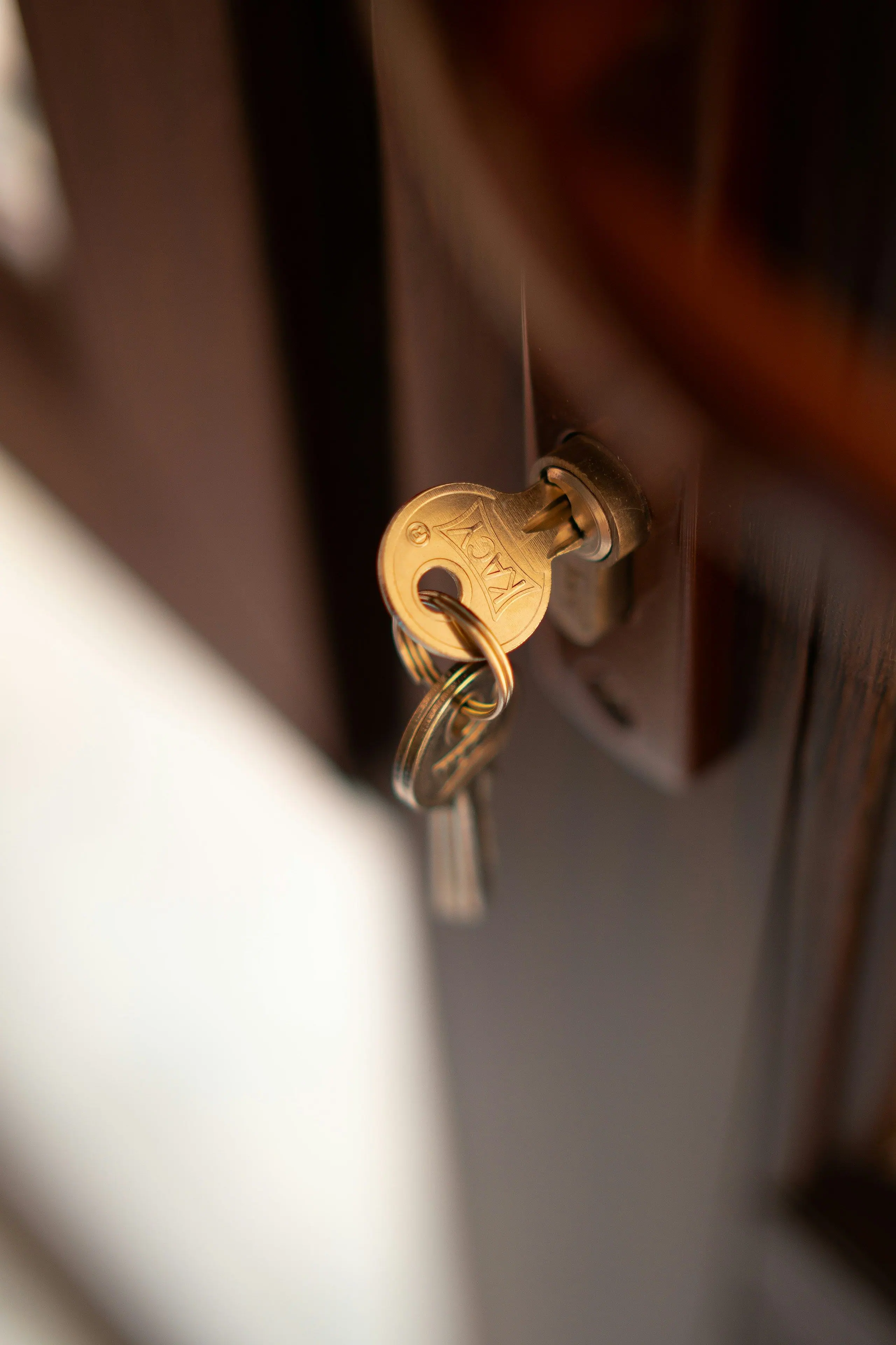 A brass key with a key ring in a front door lock