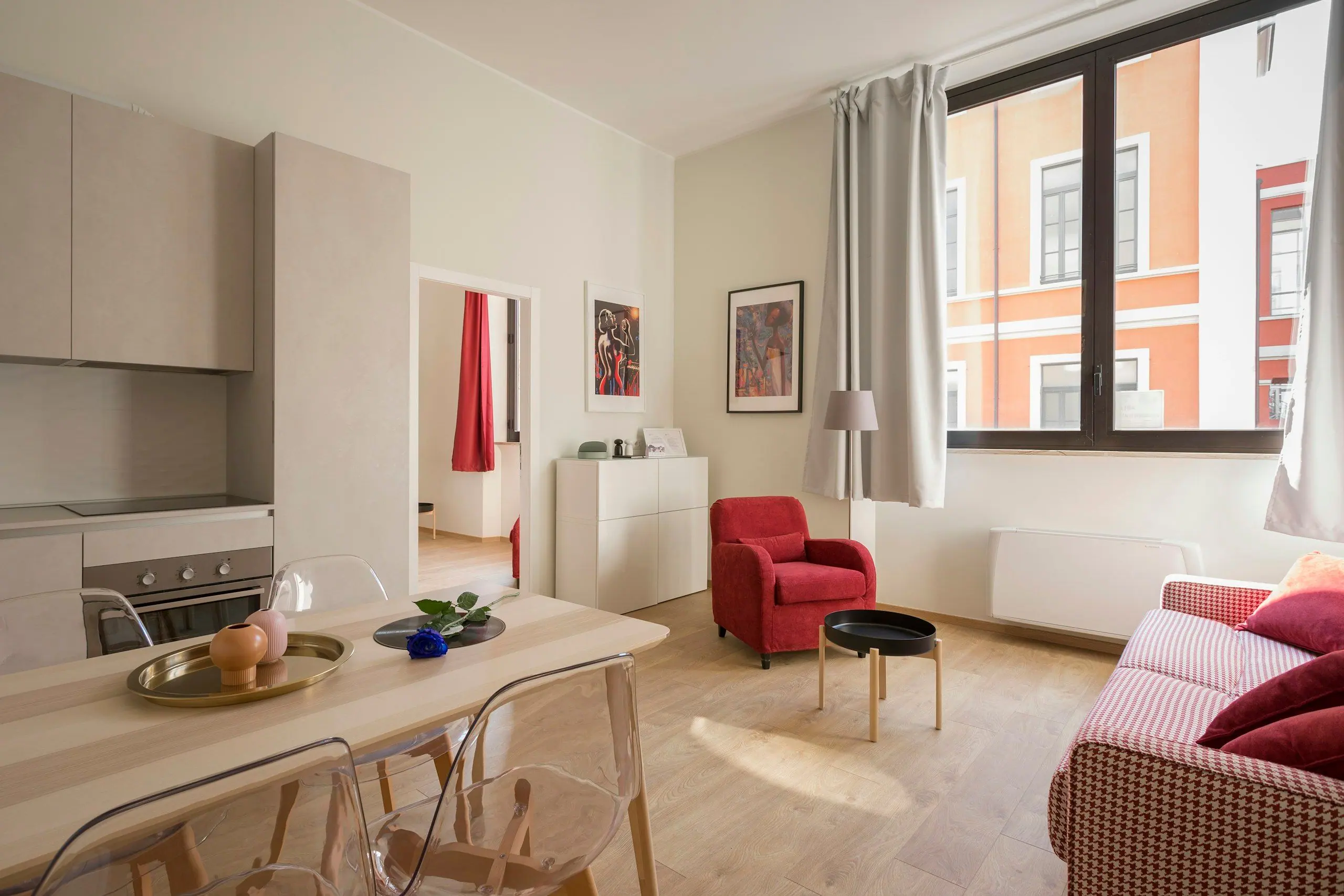 A bright open-plan flat with a kitchen, dining table and sofa